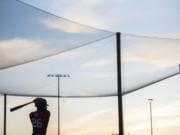 Walla Walla's Emmanuel Dean warms up while on deck to bat during a game against the Raptors in Ridgefield on Friday night, June 28, 2019.(Nathan Howard/The Columbian)