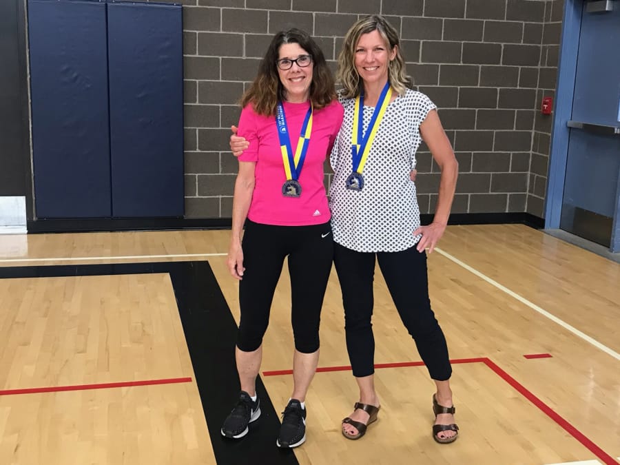 Battle Ground: Sandee Myers, left, and Krista Roadifer wear medals from participating in the 123rd annual Boston Marathon in April. Myers is a physical education teacher at Captain Strong Primary School, and Roadifer is a counselor at Chief Umtuch Middle School.