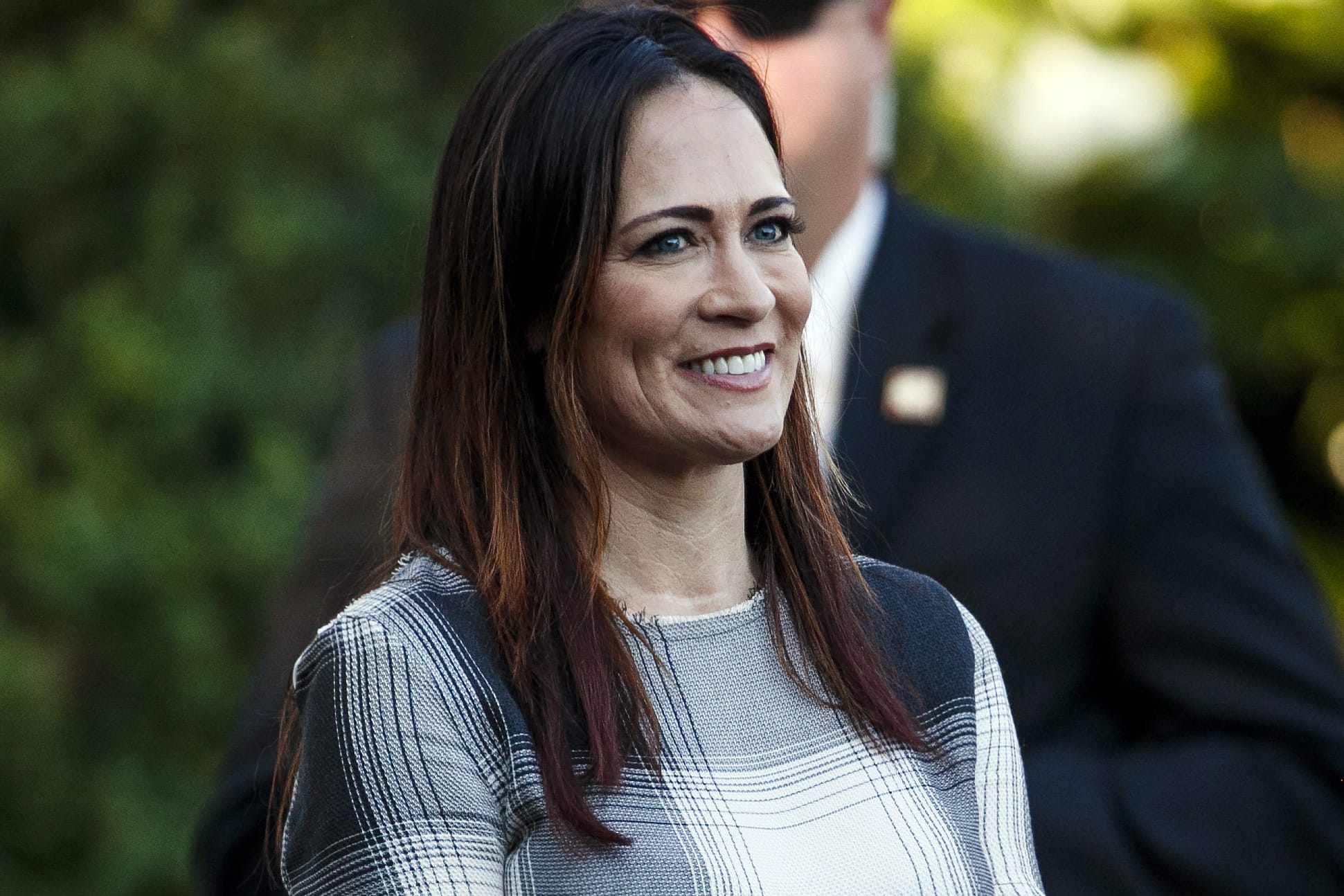 In this June 21, 2019 photo, Stephanie Grisham, spokeswoman for first lady Melania Trump, watches as President Donald Trump and the first lady greet attendees during the annual Congressional Picnic on the South Lawn in Washington. First lady Melania Trump has announced that Grisham will be the new White House press secretary. Grisham, who has been with President Donald Trump since 2015, will also take on the role of White House communications director.