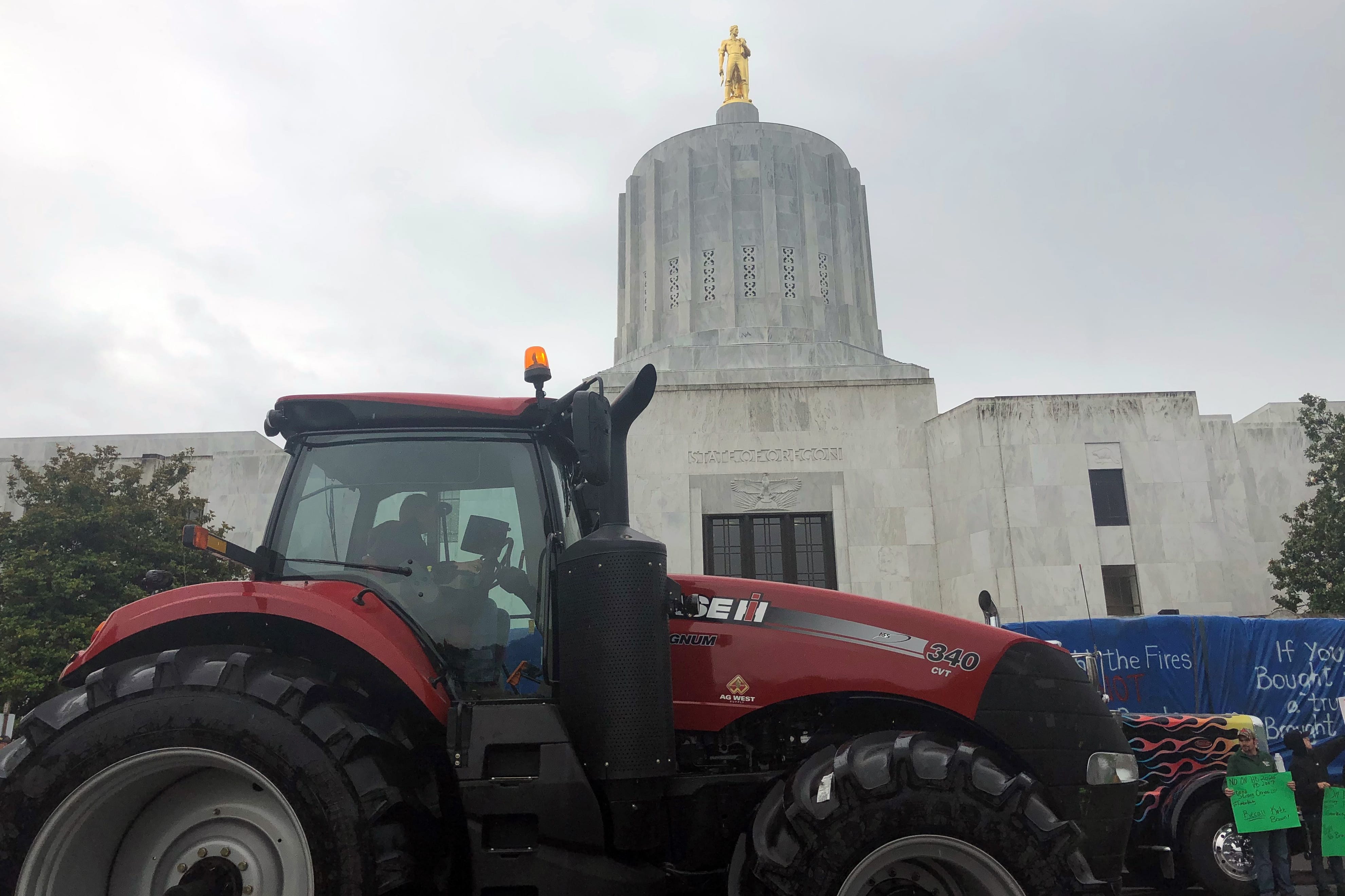 A convoy of trucks and tractors circle the Oregon state Capitol on Thursday, June 27, 2019 in Salem, Ore. Protesters are supporting the eleven Republican senators who walked out over a week ago to avoid a vote on climate legislation.