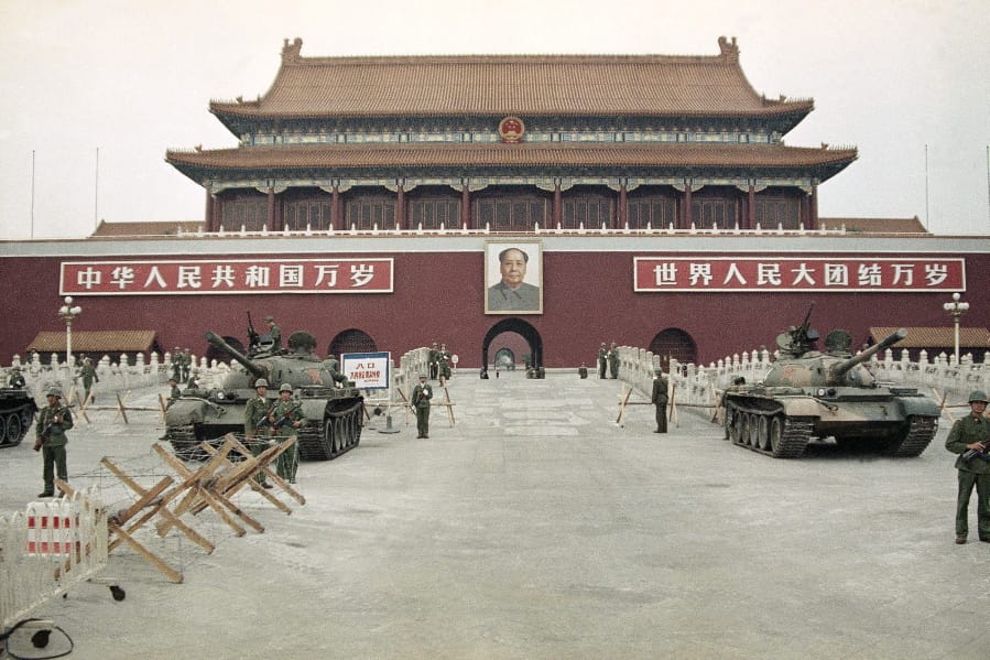 FILE - In this June 10, 1989 file photo, People’s Liberation Army (PLA) troops stand guard with tanks in front of Tiananmen Square after crushing the students pro-democracy demonstrations in Beijing. Thirty years since the Tiananmen Square protests, China’s economy has catapulted up the world rankings, yet political repression is harsher than ever.