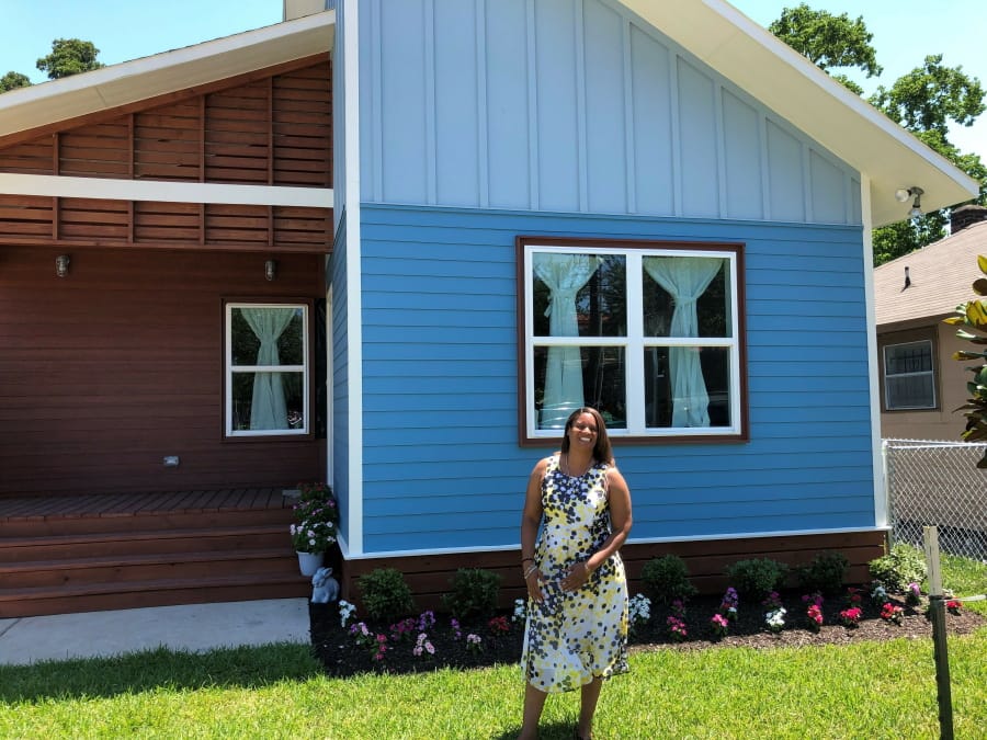 Houston resident Scenacia Jones stands in front of her new home Wednesday. It is part of a program that builds houses after natural disasters and lets families live in one part of the structure while the rest is completed.