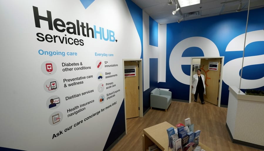 In this Thursday, May 30, 2019 photo, family Nurse Practitioner Serena Lopez exits an exam room at the new HealthHUB inside a CVS store in Spring, Texas. HealthHUB locations offer a broader range of health care services, new product categories, digital tools and on-demand health kiosks, trusted advice and personalized care. (AP Photo/David J.