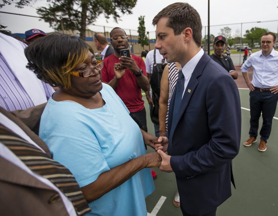 In this Wednesday, June 19, 2019 photo, South Bend Mayor and Democratic presidential candidate Pete Buttigieg shares a moment with Shirley Newbill, mother of Eric Logan, during a gun violence memorial at the Martin Luther King Jr. Recreation Center in South Bend, Ind.