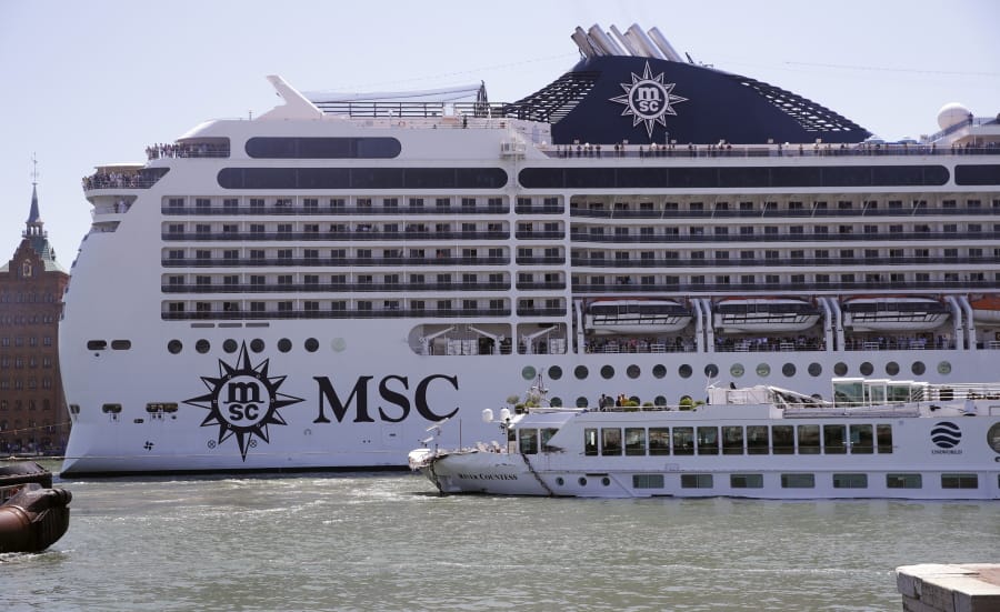 The MSC Magnifica cruise ship passes by the tourist boat, foreground, bottom right, that was struck by a towering cruiser, foreground right, in Venice, Italy, Sunday, June 2, 2019. The MSC Opera cruise ship has struck a dock and a tourist river boat on a busy canal in Venice. Italian media report that at least five people have been injured in the crash.