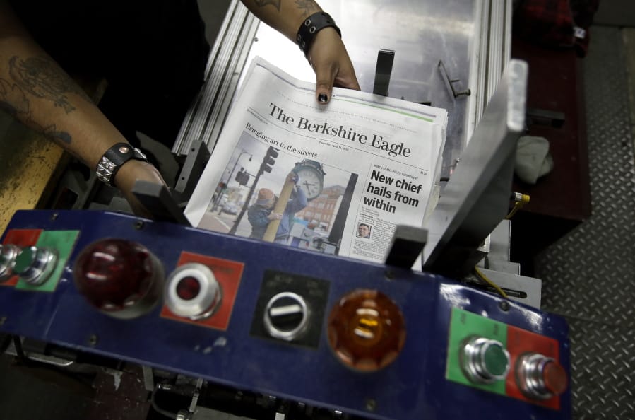 In this Thursday, April 11, 2019 photo, copies of The Berkshire Eagle newspaper are placed in a machine before being bundled for distribution, in Pittsfield, Mass. The paper now features a new 12-page lifestyle section for Sunday editions, a reconstituted editorial board, a new monthly magazine, and the newspaper print edition is wider. That level of expansion is stunning in an era where U.S. newspaper newsroom employment has shrunk by nearly half over the past 15 years.