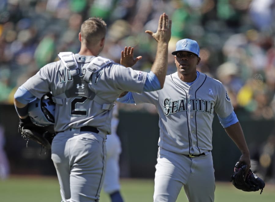 Seattle Mariners pitcher Roenis Elias, right, celebrates with Tom Murphy (2) after their win over the Oakland Athletics in a baseball game Sunday, June 16, 2019, in Oakland, Calif.