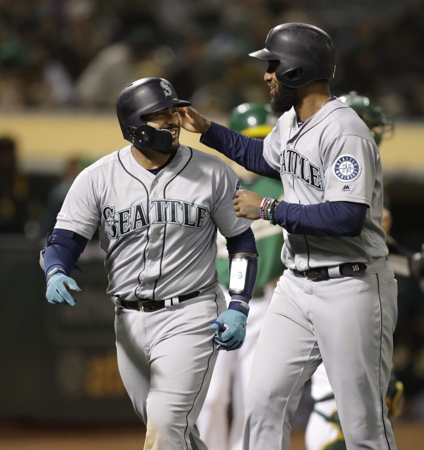 Seattle Mariners’ Omar Narvaez, left, celebrates with Domingo Santana after hitting a two-run home run off Oakland Athletics’ Wei-Chung Wang during the seventh inning of a baseball game Friday, June 14, 2019, in Oakland, Calif.
