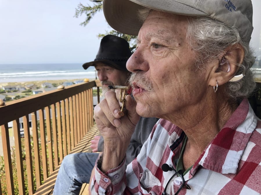 Two-time cancer survivor and medical marijuana cardholder Bill Blazina, 73, smokes a marijuana joint on the deck of his neighbor’s home April 25 in Waldport, Ore. Blazina also uses a high-potency marijuana oil, which he can’t afford to buy at a recreational marijuana store. Blazina has learned how to make his own oil in a rice cooker after watching videos online.