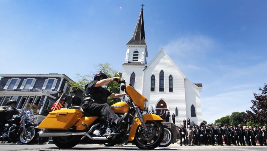 Members of the Jarheads Motorcycle Club pass police honor guards as they roll up to the funeral for Michael Ferazzi at St. Peter’s Catholic Church in Plymouth, Mass., Friday, June 28, 2019. Ferazzi, a motorcyclist and retired police officer, was killed in a fiery crash that claimed the lives of seven people riding with the Jarheads Motorcycle Club in New Hampshire.