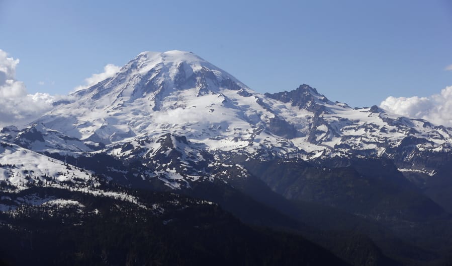 FILE - In this file photo taken June 19, 2013, Mount Rainier is seen from a helicopter flying south of the mountain and west of Yakima, Wash. A helicopter rescued four climbers from near the summit of Mount Rainier Thursday, June 6, 2019, after they had been stranded on the Cascade Mountain peak for several days.