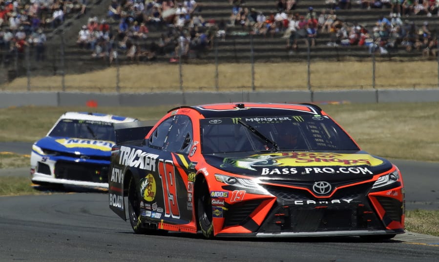 Martin Truex Jr., right, leads Chase Elliott through a turn during a NASCAR Sprint Cup Series auto race Sunday, June 23, 2019, in Sonoma, Calif.
