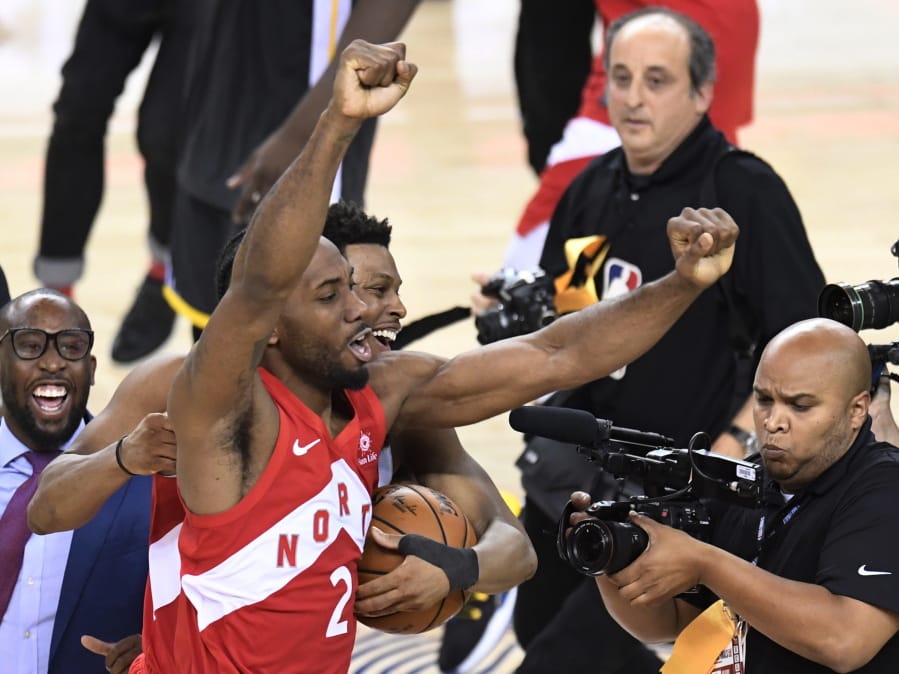 Toronto Raptors forward Kawhi Leonard (2) and guard Kyle Lowry, back, celebrate after the Raptors defeated the Golden State Warriors 114-110 in Game 6 of basketball’s NBA Finals, Thursday, June 13, 2019, in Oakland, Calif.