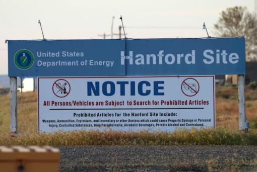 FILE - In this May 9, 2017 file photo, signs are posted near the entrance to the Hanford Nuclear Reservation in Richland, Wash. A federal judge on Thursday, June 13, 2019 rejected the Trump administration’s challenge to a Washington state law that makes it easier for former workers at the Hanford Nuclear Reservation to win workers compensation benefits.
