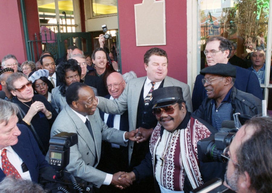 Fats Domino, center right, shakes hands with Dave Bartholomew, left, amid a crowd of former colleagues at the 50th anniversary observance of Domino’s first recording session on Dec. 10, 1999, in New Orleans.