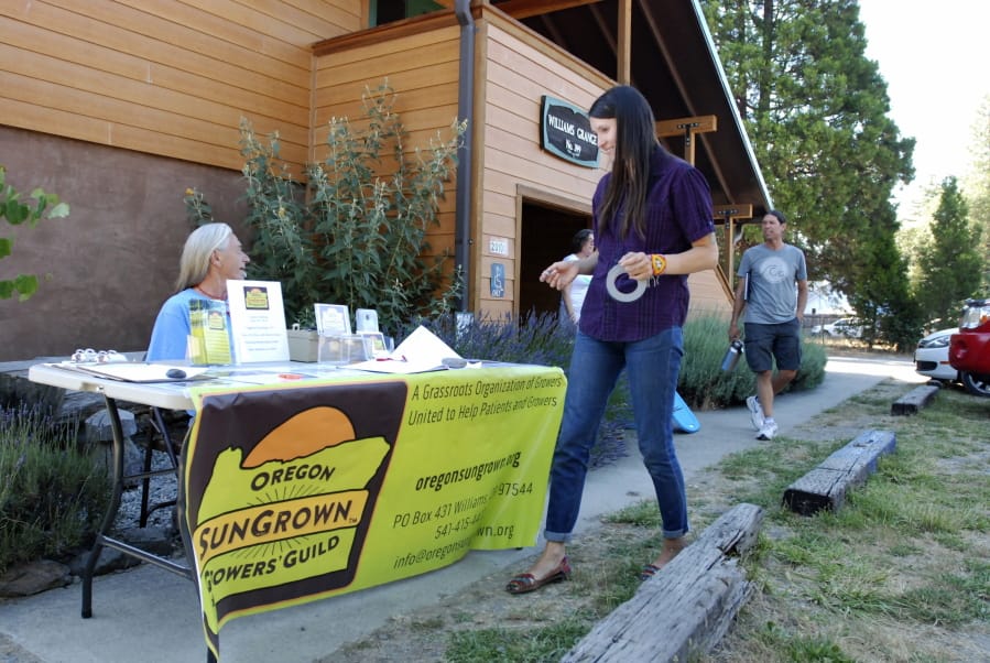 Gina Erdmann, director of the Oregon SunGrown Growers’ Guild, sets up a sign-in table for the monthly meeting of marijuana growers on June 25, 2015, in Williams, Ore.
