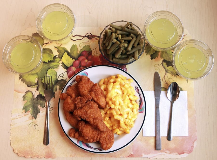 This undated photo provided by the National Institutes of Health in June 2019 shows an “ultra-processed” lunch including brand name macaroni and cheese, chicken tenders, canned green beans and diet lemonade. Researchers found people ate an average of 500 extra calories a day when fed mostly processed foods, compared with when the same people were fed minimally processed foods. That’s even though researchers tried to match the meals for nutrients like fat, fiber and sugar.
