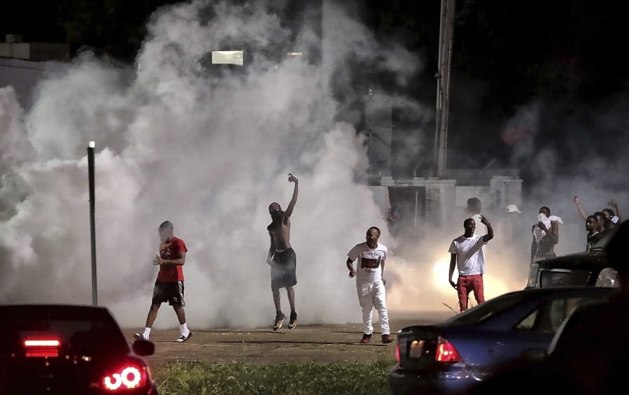 Frayser community residents taunt authorities as protesters take to the streets in anger against the shooting of a youth identified by family members as Brandon Webber by U.S. Marshals earlier in the evening, Wednesday, June 12, 2019, in Memphis, Tenn. Dozens of angry protesters clashed with police throwing stones and tree limbs until police forces broke the mob up with tear gas.