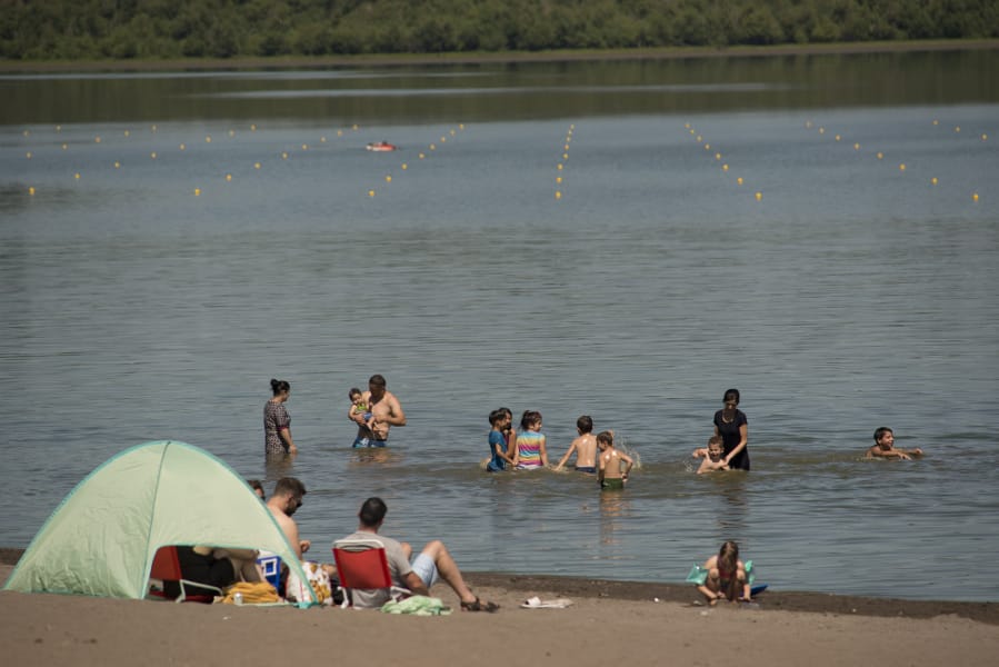 Swimmers at Vancouver Lake enjoy a hot Sunday afternoon despite health advisories about E. coli and blue-green algae over the past few weeks.