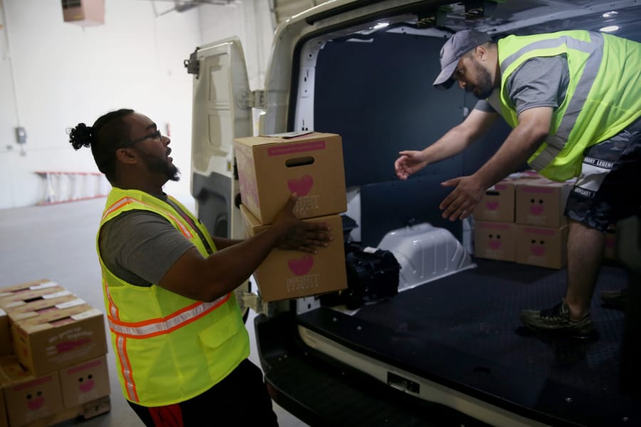 Line haul driver Jesse Penn, left, helps delivery driver Younes Khalil load produce boxes into his van at the Imperfect Produce warehouse in Pennsauken, N.J., on Wednesday, May 22, 2019. The company sells packages of surplus produce that do not meet the aesthetic standards required by grocery stores.