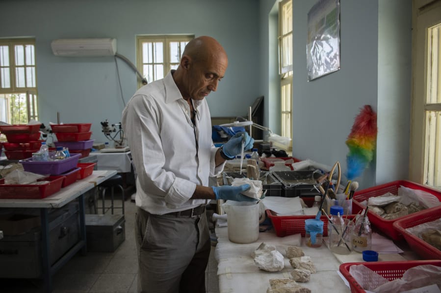 Fabio Colombo, senior conservator and the head of a restoration project at the National Museum of Afghanistan in Kabul, Afghanistan, sifts through remnants of Buddha figurines in June, 2019.