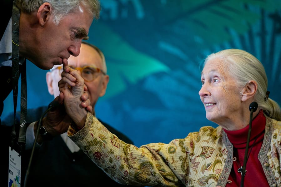 Tracy R. Wolstencroft, president and CEO of the National Geographic Society, kisses the fingernail of Jane Goodall, the famed chimp researcher, before she speaks at a press conference at the Hilton San Diego Bayfront on July 9 in San Diego. Goodall spoke alongside Environmental Systems Research Institute founder Jack Dangermond and biologist E.O. Wilson.