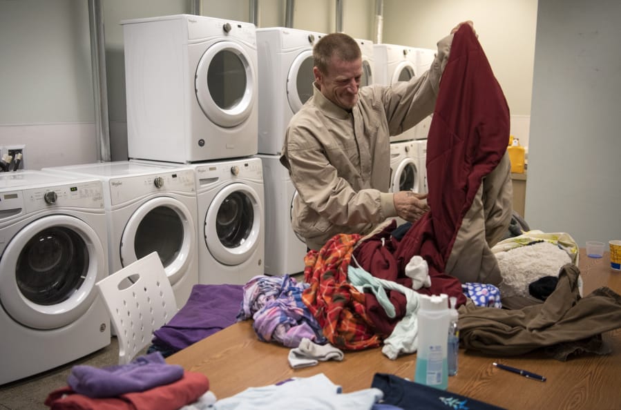 Robert Thompson folds laundry at the Vancouver Navigation Center on June 27. Laundry is one of the most used services. Thompson lives out of his car with his partner, and they come to the day center every day. “They’re doing really good here,” he said.