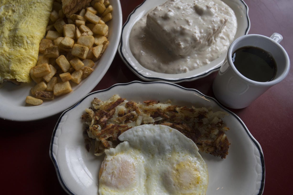 A jalapeno-and-mushroom omelette with toast and fried potatoes, clockwise from left, biscuits and gravy and the two-egg breakfast with hash browns at Christine’s.