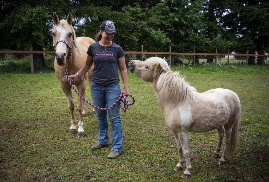 U.S. Air Force Academy graduate Kristen Nye is pictured with her horse Sunny and her mom’s miniature horse Zoomie at her La Center home in June. Nye brought Sunny with her to the academy and competed on the school’s rodeo team.