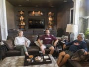 Marykay Lamoureaux, from left, and Raptors coaches Chris Cota and Rob Paramo sit in Lamoureaux’s Ridgefield home, where she and her husband, Chris, are hosting the two coaches this summer while the Raptors play their first season. The coaches have a space to themselves in the basement, complete with two bedrooms, a living room and a separate entrance.