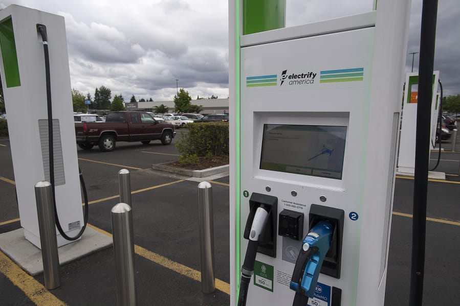 A motorist passes by an electric vehicle charging station at the Walmart store in Hazel Dell. Electrify America and Walmart have installed electric vehicle charging stations at Walmart stores across Washington, including this one in Vancouver. This effort is part of a broader plan to develop a coast-to-coast EV charging network, which would make Walmart one of the largest retail hosts of EV charging stations across the United States.
