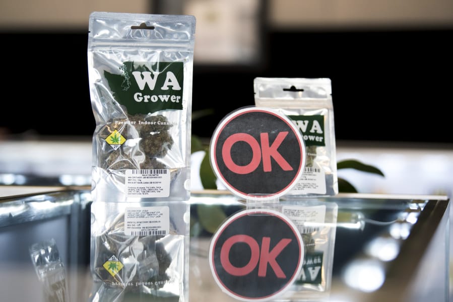 An OK Cannabis sign is displayed with marijuana products at Main Street Marijuana in Vancouver. The industry-led program randomly pulls products from store shelves to test for pesticides and other contaminants.