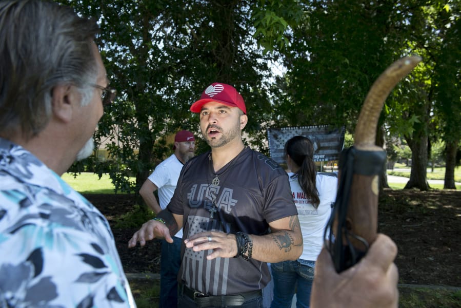 Patriot Prayer’s Joey Gibson talks with supporters after a rally in support of Battle Ground city council candidates Shauna Walters and Josh VanGelder.