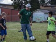 Julian Charbonneau, from left, Portland Timbers mascot Joey Webber, also known as Timber Joey, with Ezequiel Valencia and Chase Anderson, kick the ball around during a game of keep away Thursday morning at Fruit Valley Elementary School.