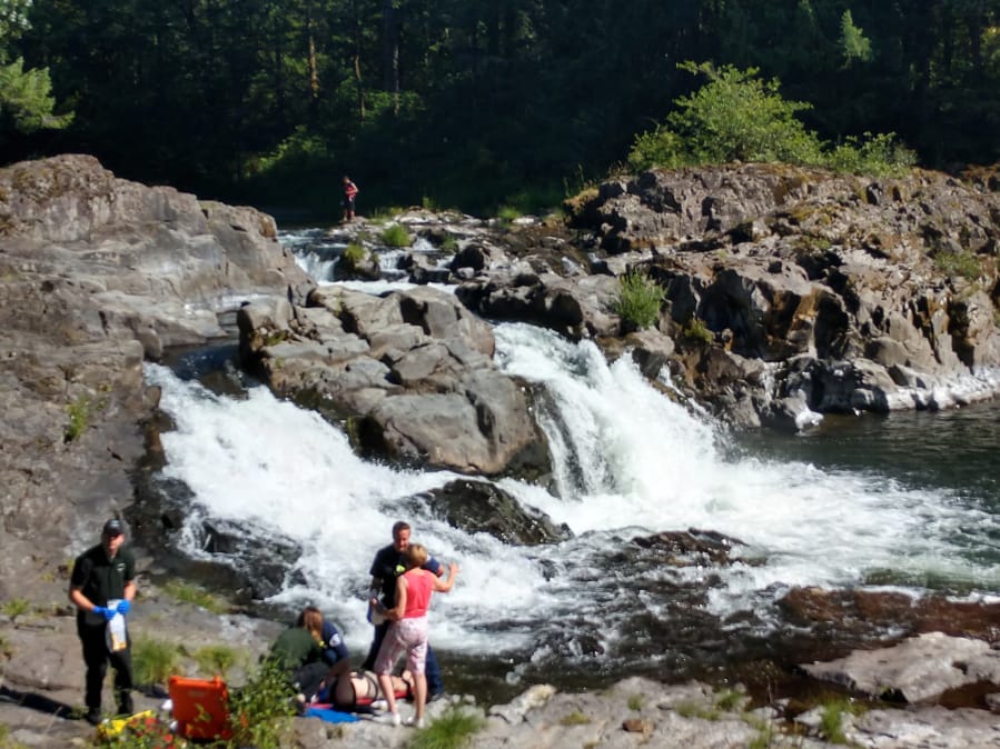 Medical personnel tend to Robert Brown, 52, of Vancouver after he tumbled down a 15-foot, rocky waterfall Sunday afternoon at Lucia Falls Regional Park.