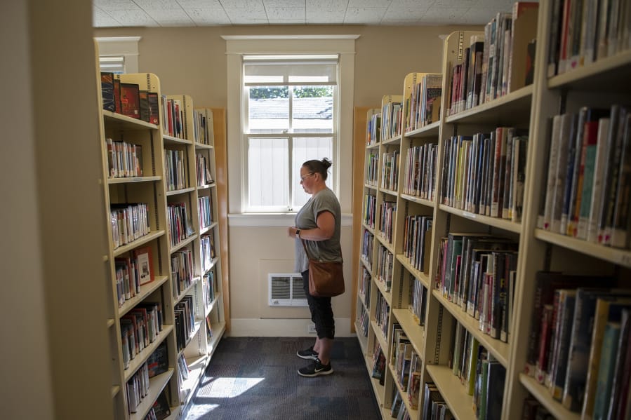 Carey Hanson of Woodland searches for a few books to read at the Woodland Community Library. “I love this library. I’m always here,” Hanson said from a cramped aisle of the library in 2019.