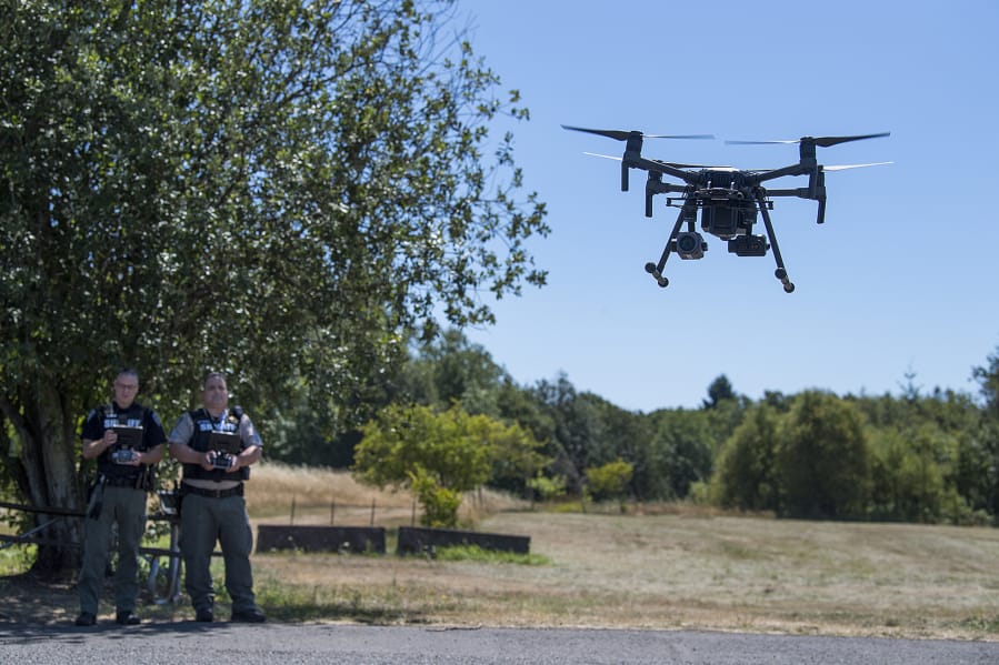 Detective Todd Young, left, and Sgt. Jason Granneman demonstrate one of the drones they use while working in the field at the Clark County Sheriff’s Office’s West Precinct.