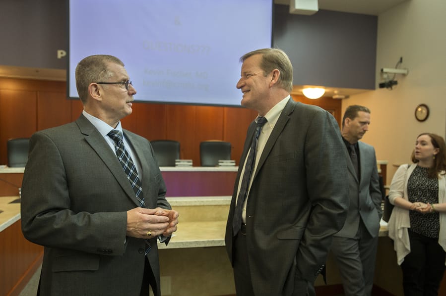 Chief Ric Bishop of the Clark County Jail, left, chats with Craig Pridemore, CEO of Columbia River Mental Health Services, following a meeting Thursday morning at the Clark County Public Service Center. The jail is partnering with the nonprofit to expand opioid treatment in the jail.