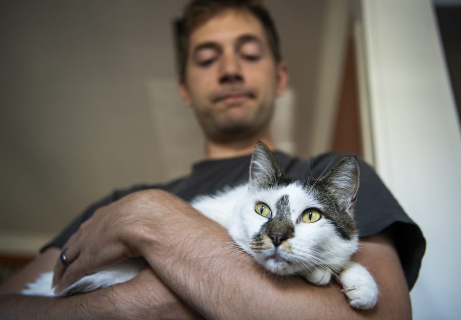 Reid Syverson holds his cat Jack on Thursday at their home in Vancouver. Jack was taken from their home seven weeks ago and was reunited with Syverson and his wife Nora on Wednesday. “We’re just hoping his stress goes down,” Reid Syverson said.