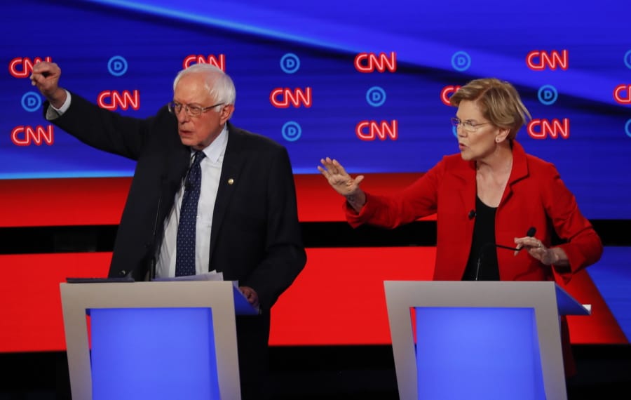 Sen. Bernie Sanders, I-Vt., and Sen. Elizabeth Warren, D-Mass., talk during in the first of two Democratic presidential primary debates hosted by CNN Tuesday, July 30, 2019, in the Fox Theatre in Detroit.