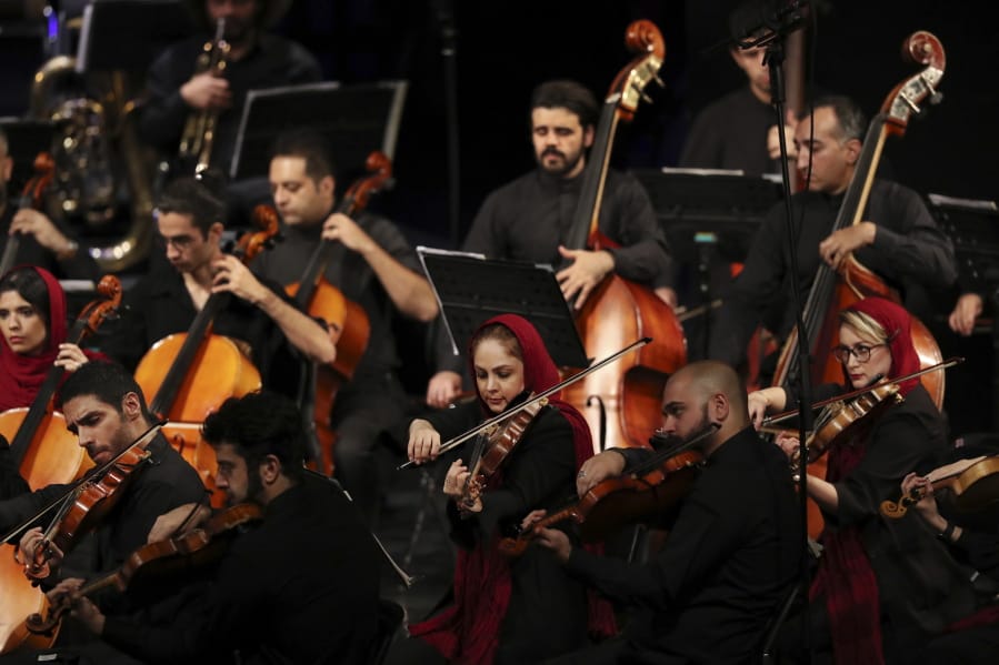 In this Wednesday, July 3, 2019 photo, Iranian musicians play while performing 19th century Russian composers in Tehran Symphony Orchestra at Unity Hall, in Tehran, Iran.