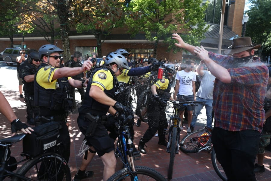 After a confrontation between authorities and protestors, police use pepper spray as multiple groups, including Rose City Antifa, the Proud Boys and others protest in downtown Portland, Ore., on Saturday, June 29, 2019. In separate social media posts later in the day, police declared the situation to be a civil disturbance and warned participants faced arrest.