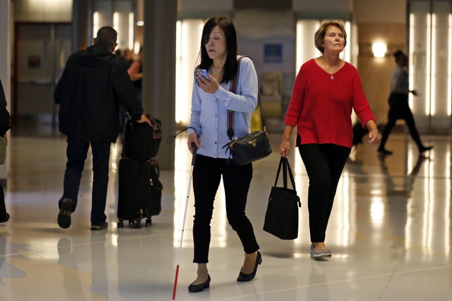 This June 9, 2019 photo shows Chieko Asakawa using the airport wayfinding app that she and her team at Carnegie Mellon University to navigate through Pittsburgh International Airside terminal in Imperial, Pa. before boarding a flight to Japan. (AP Photo/Gene J.