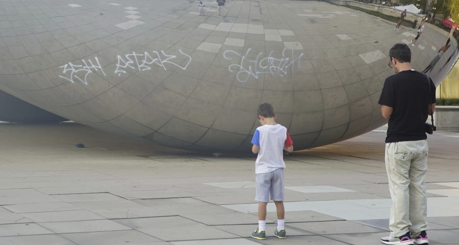 Graffiti mars the popular giant metallic sculpture known as “The Bean,” Tuesday, July 2, 2019, in Chicago.