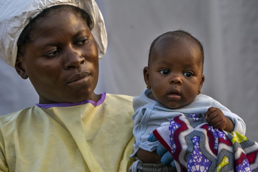 In this Wednesday, July 17, 2019 photo, 2-month-old Lahya Kathembo is carried by a nurse waiting for test results at an Ebola treatment center in Beni, Congo. Lahya became an orphan in a day. Her mother succumbed to Ebola on a Saturday morning. By sunset her father was dead. Her tests came back negative for Ebola.