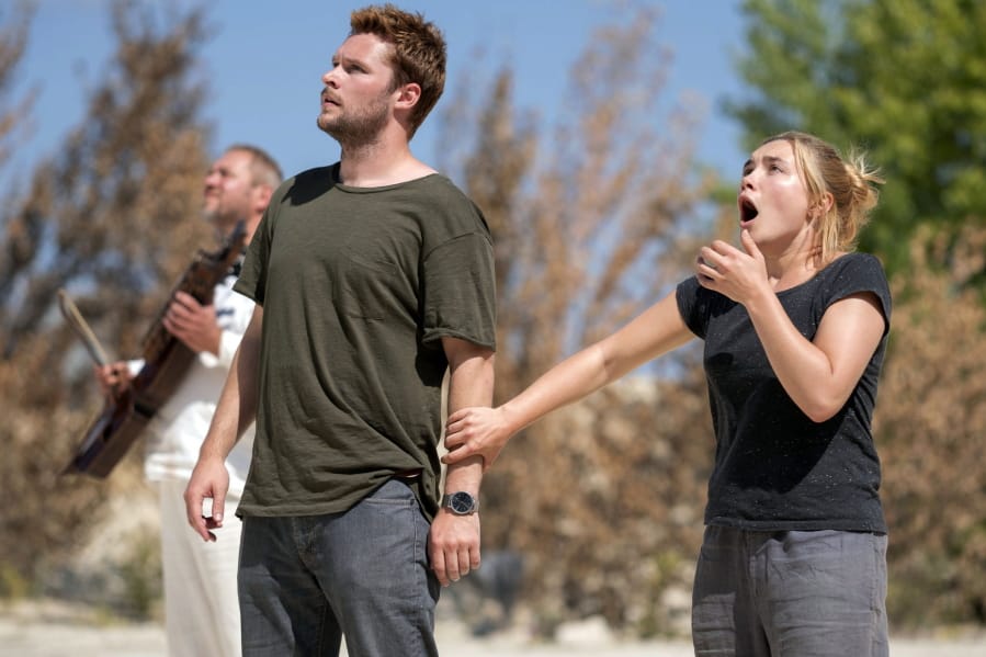 This image released by A24 shows Jack Reynor and Florence Pugh, right, in a scene from the horror film “Midsommar.” (Gabor Kotschy/A24 via AP)