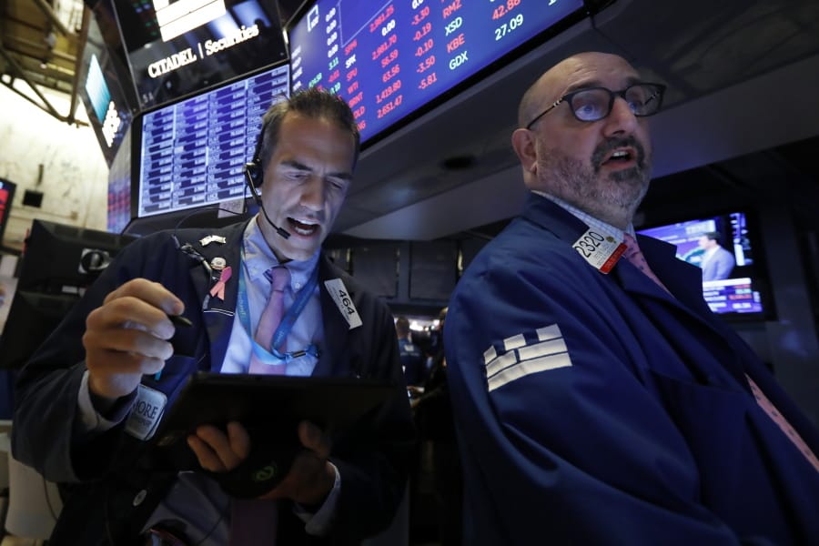 Trader Gregory Rowe, left, and specialist Peter Giacchi work on the floor of the New York Stock Exchange, Thursday, July 18, 2019. U.S. stocks moved lower in early trading on Wall Street Thursday after Netflix reported a slump in new subscribers and dragged down communications companies.