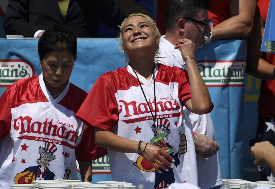 Miki Sudo, right, reacts after eating 31 hot dogs to win the women’s competition of Nathan’s Famous July Fourth hot dog eating contest, Thursday, July 4, 2019, in New York’s Coney Island.