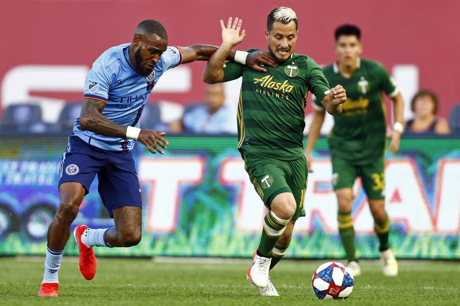 Portland Timbers midfielder Sebastian Blanco (10) battles for the ball with New York City defender Sebastien Ibeagha, left, during the second half of an MLS soccer match Sunday, July 7, 2019, in New York.
