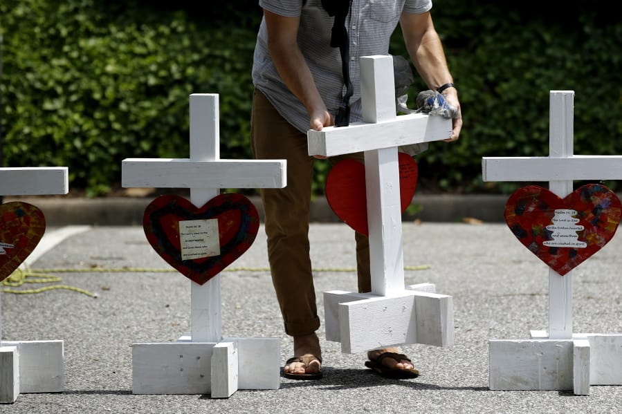 A volunteer prepares to place crosses for victims of a mass shooting at a municipal building in Virginia Beach, Va., on June 2.